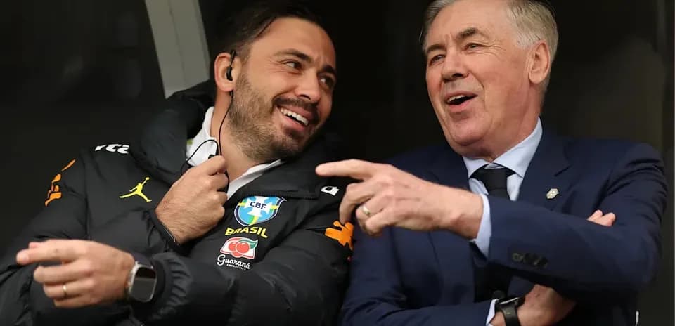 Two coaches sharing a light moment on the bench