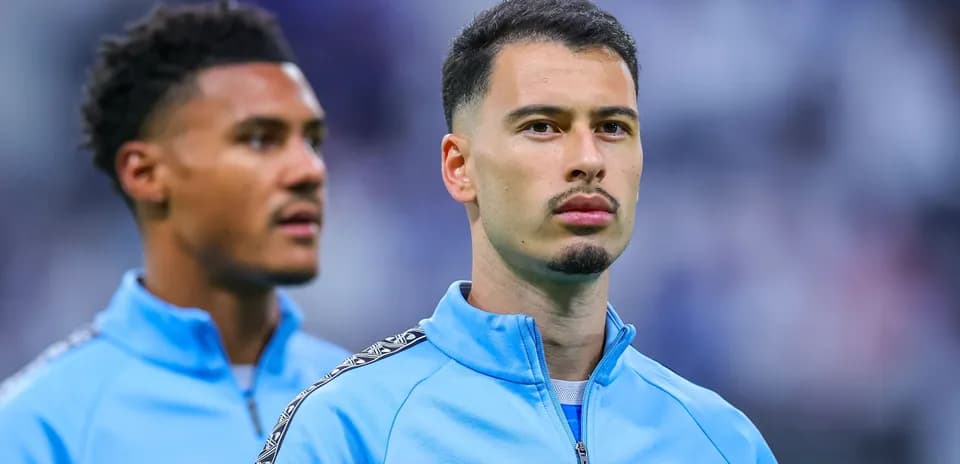 Two players in blue training jackets on pitch