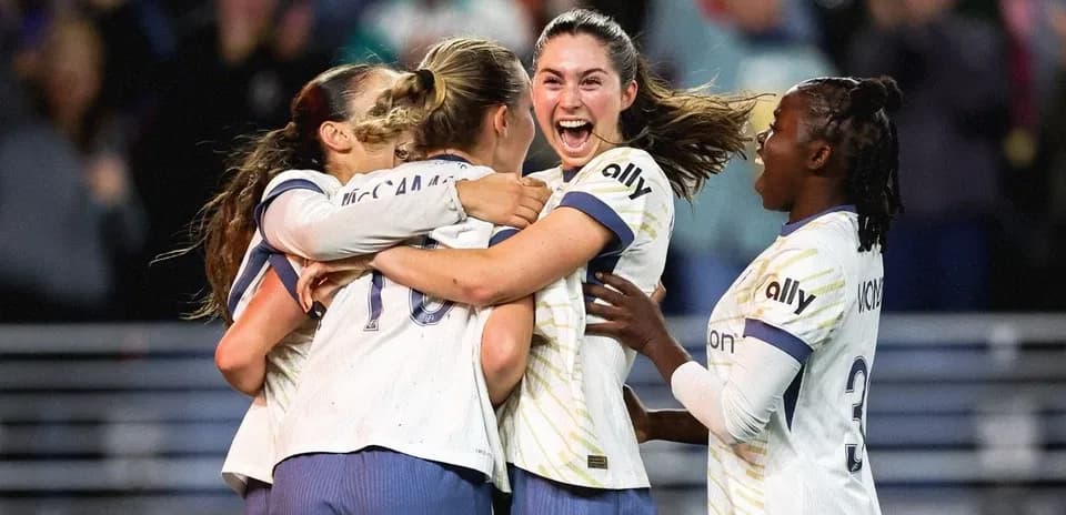 Players celebrating a goal during NWSL match