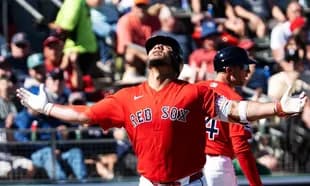 Red Sox player celebrating a hit with fans in background