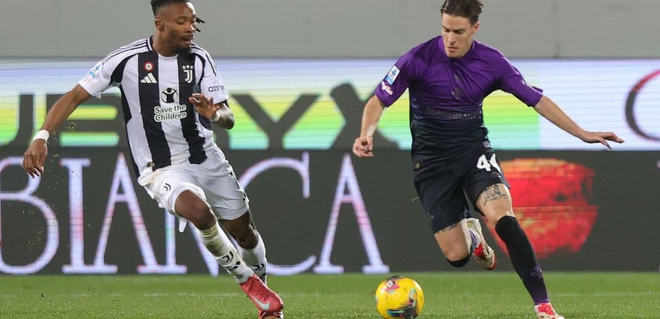 Juventus player challenging Fiorentina opponent for ball