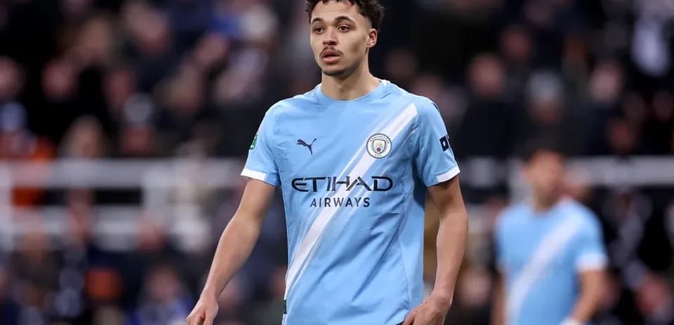 Player in light blue Manchester City jersey on pitch