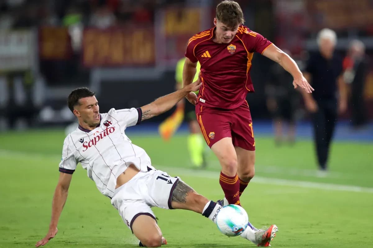 Bologna player tackling AS Roma opponent