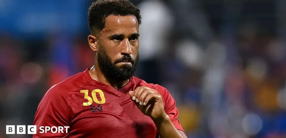 Player in red jersey during match with focused expression