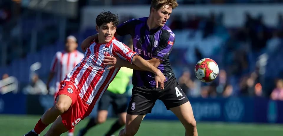 Two players battling for the ball in match
