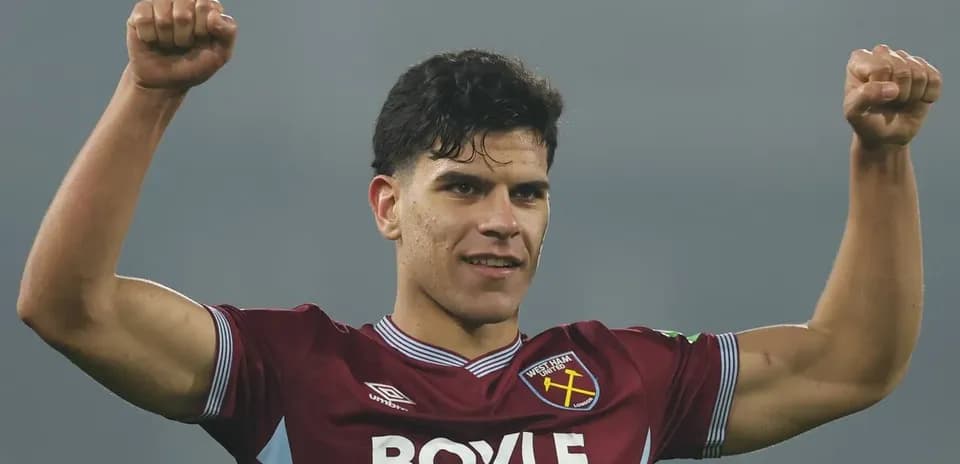 Player celebrating with raised arms in team jersey