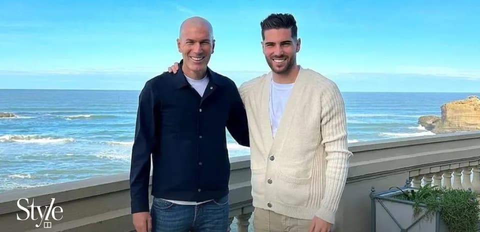 Two men posing together with ocean backdrop