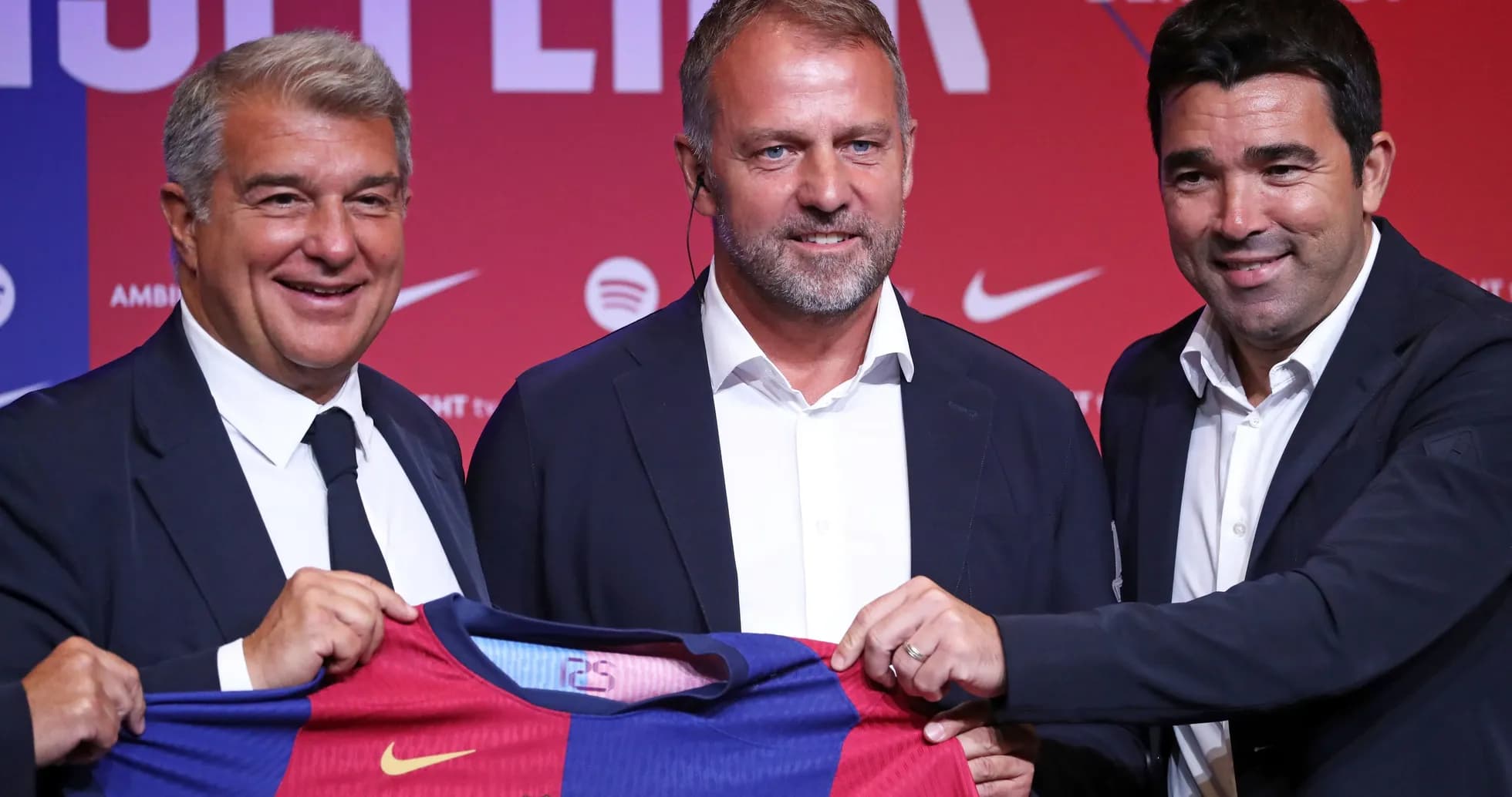 Three officials presenting FC Barcelona jersey at event
