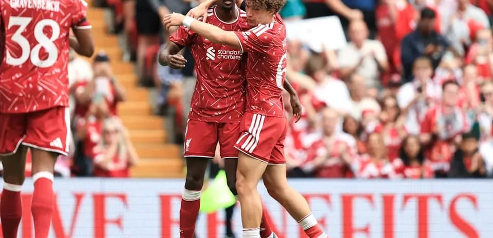 Two Liverpool players celebrating a goal on field