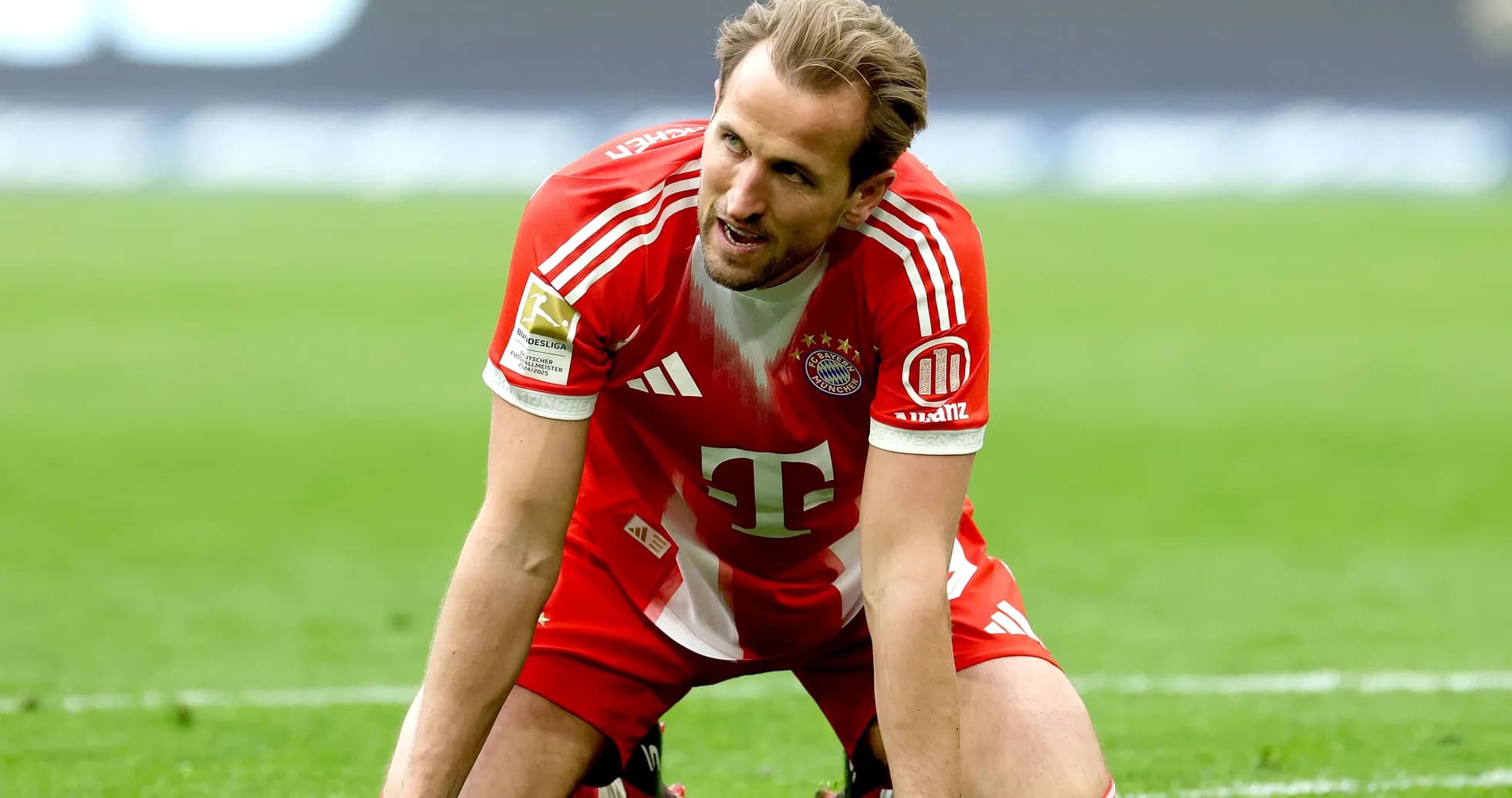 Player kneeling on pitch in Bayern Munich kit