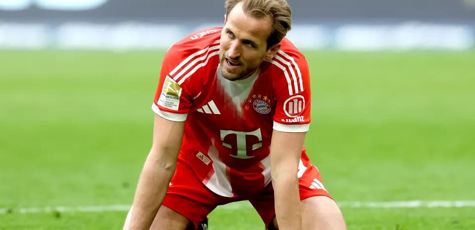 Player kneeling on pitch in Bayern Munich kit