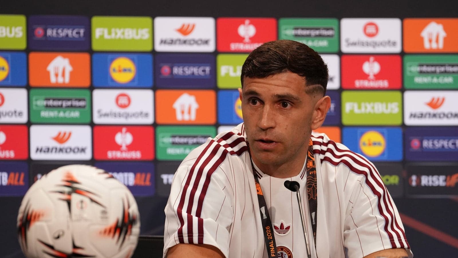 Player speaking at press conference with football