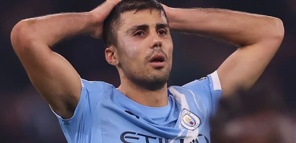 Player in Manchester City jersey with hands on head