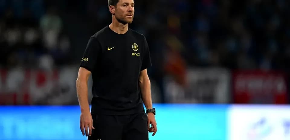 Coach walking on the pitch during match warm-up