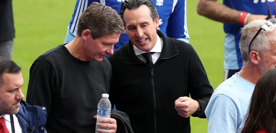 Two coaches talking on the pitch before match
