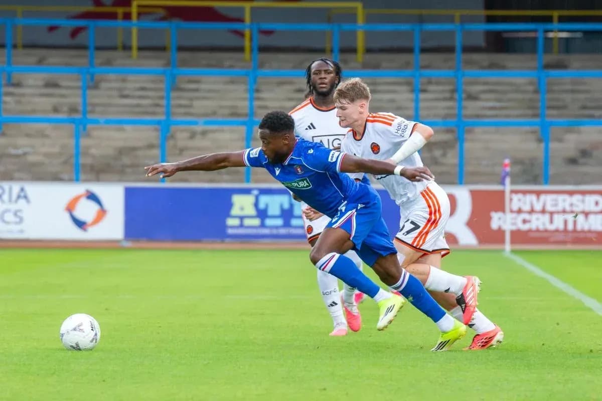 Player in blue jersey attempting to evade two defenders
