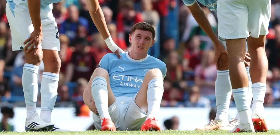 Player sitting on the ground with teammates around