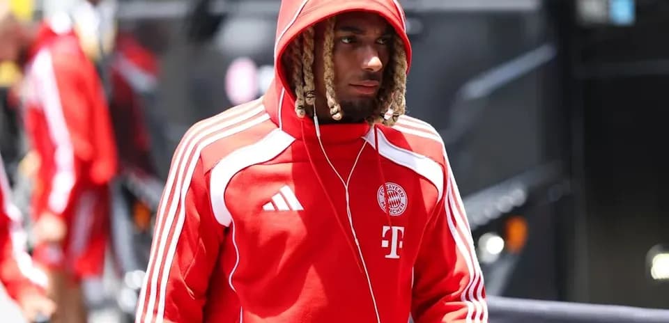 Player in red Bayern Munich hoodie arriving at venue