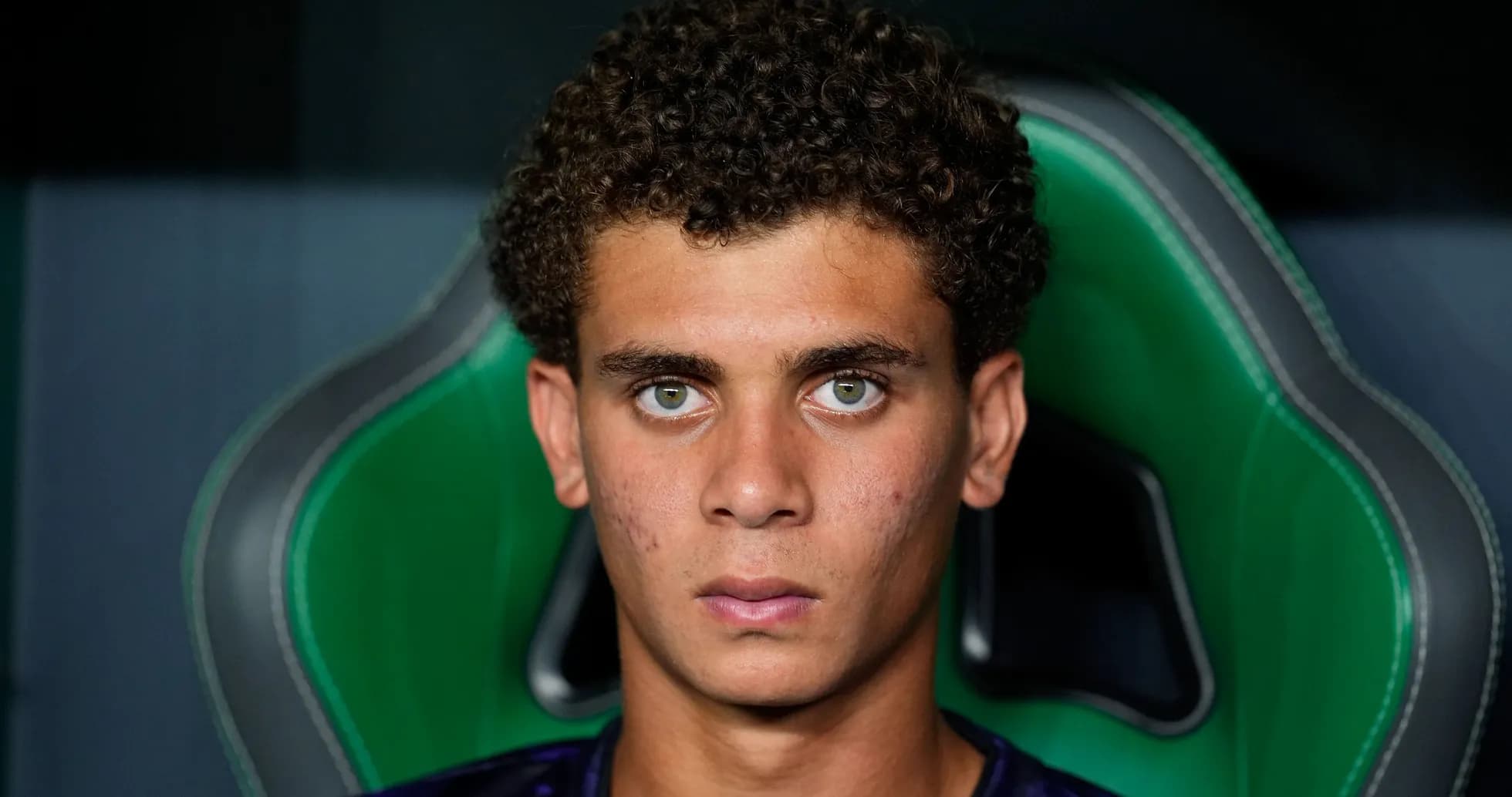 Young athlete sitting in green gaming chair