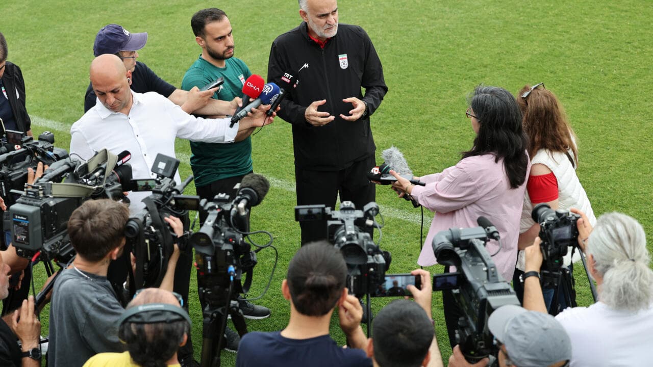 Coach addressing media during press conference on field