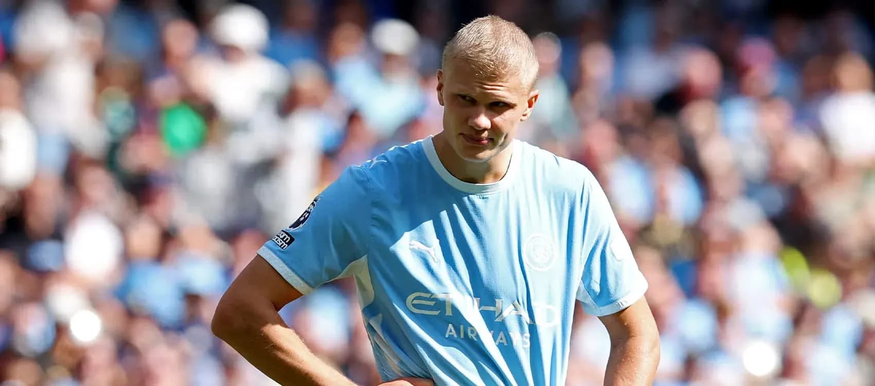 Player in light blue jersey on field with fans