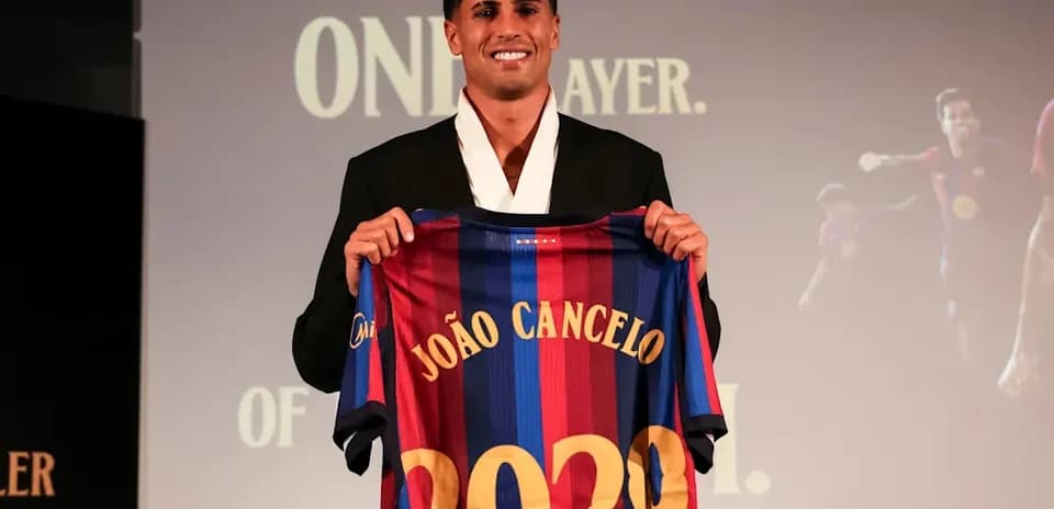 João Cancelo holding FC Barcelona jersey at event
