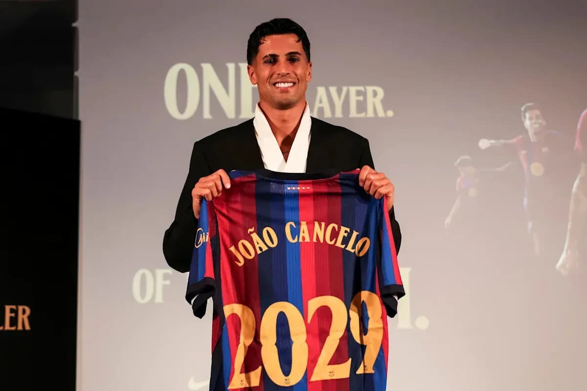 João Cancelo holding FC Barcelona jersey at event