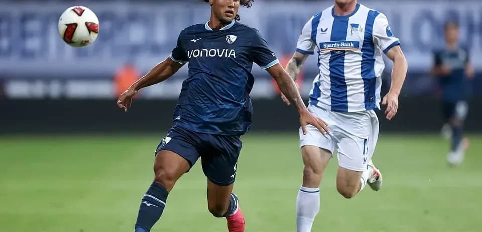 Player in blue running with the ball, defender chasing