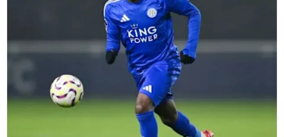 Player in blue kit running with ball on field