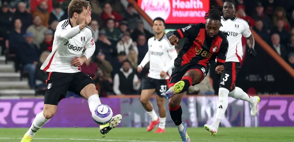 Fulham player challenges Bournemouth player for the ball