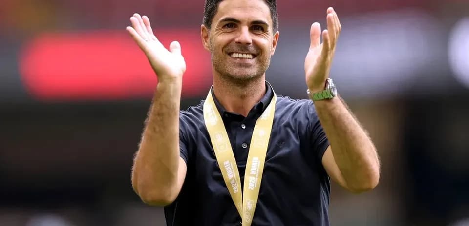 Coach applauding with medal around neck