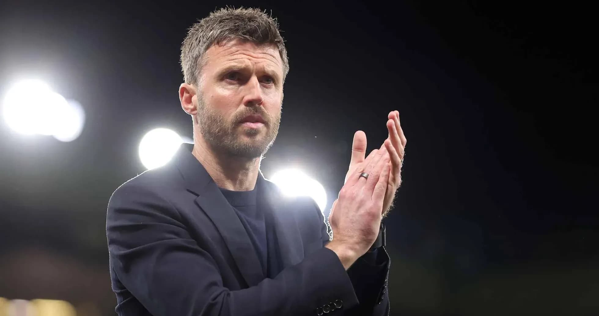 Coach applauding during a match at night