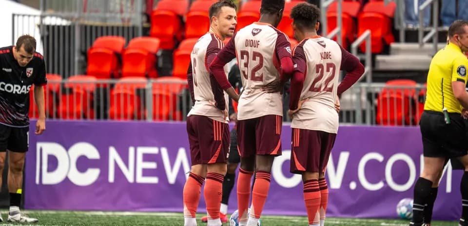 Detroit City players discussing strategy during match