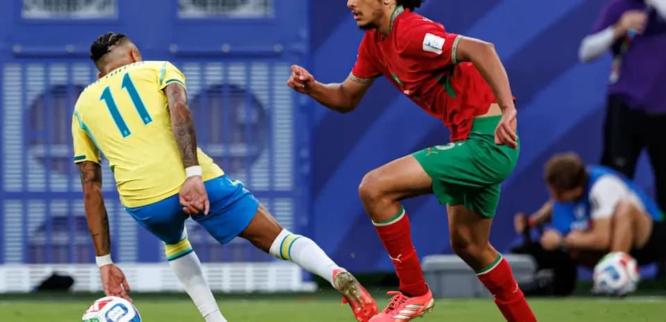 Player in yellow dribbling past opponent in red