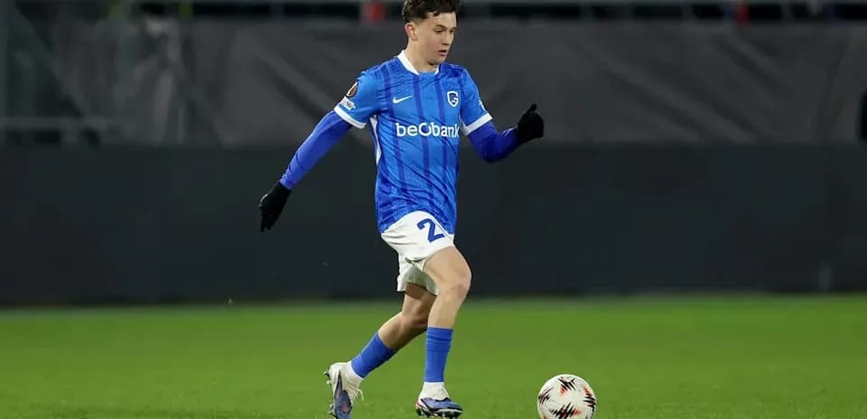 Player in blue kit dribbling ball on field