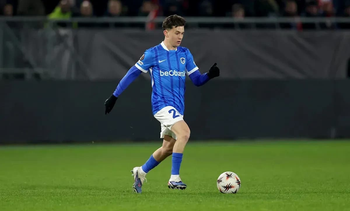 Player in blue kit dribbling ball on field