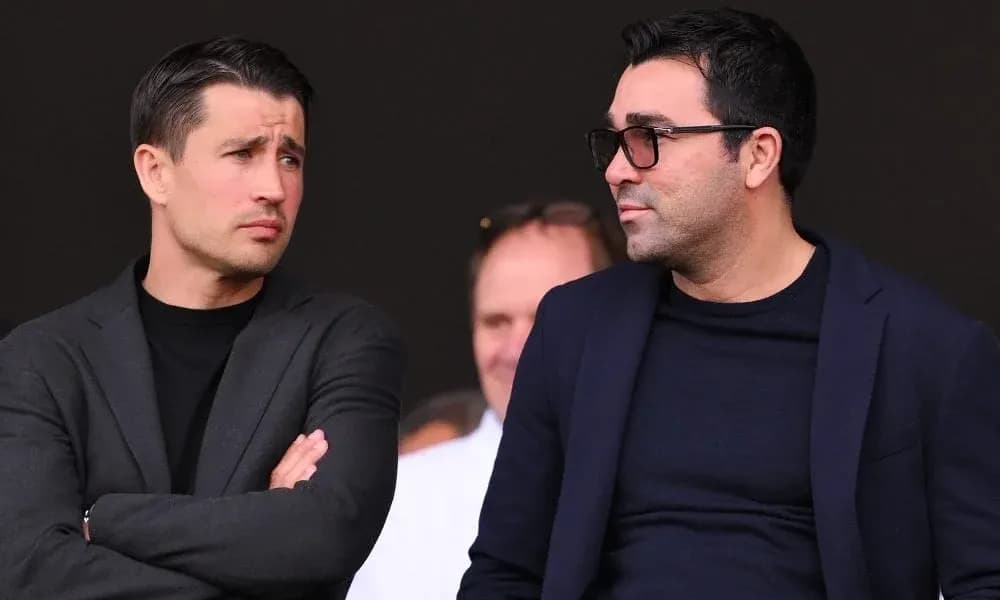 Two men conversing in a stadium setting