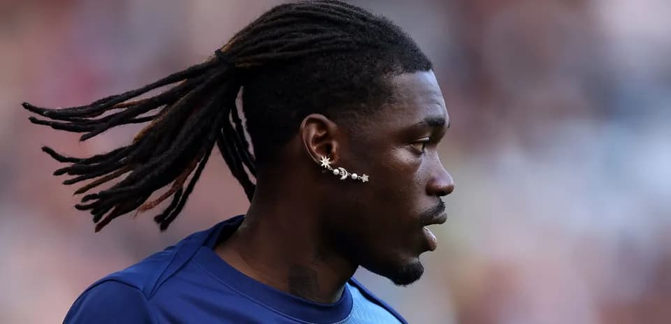 Player with dreadlocks and unique earrings on field