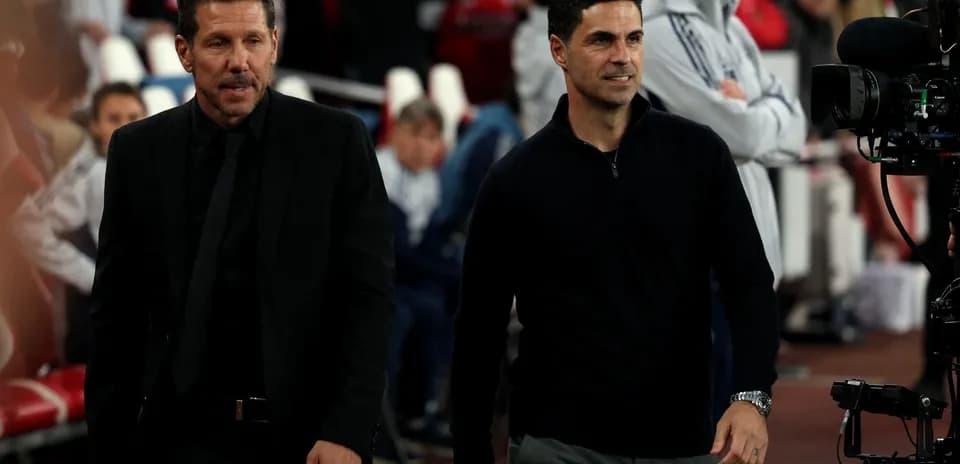 Two football managers walking on the pitch