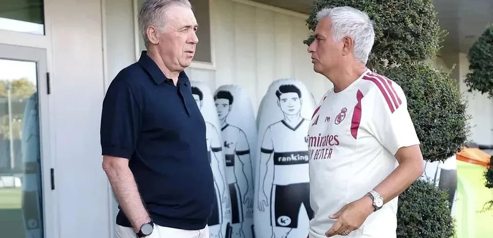 Two football managers conversing at training ground