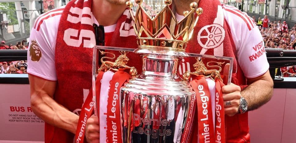 Players celebrating with Premier League trophy during parade