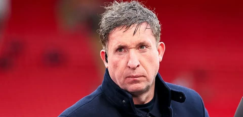 Man in a coat with earpiece at stadium