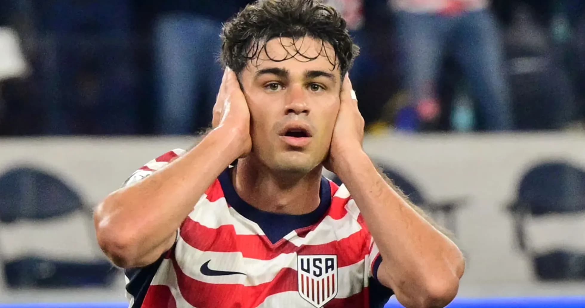 Player covering ears during intense moment on field