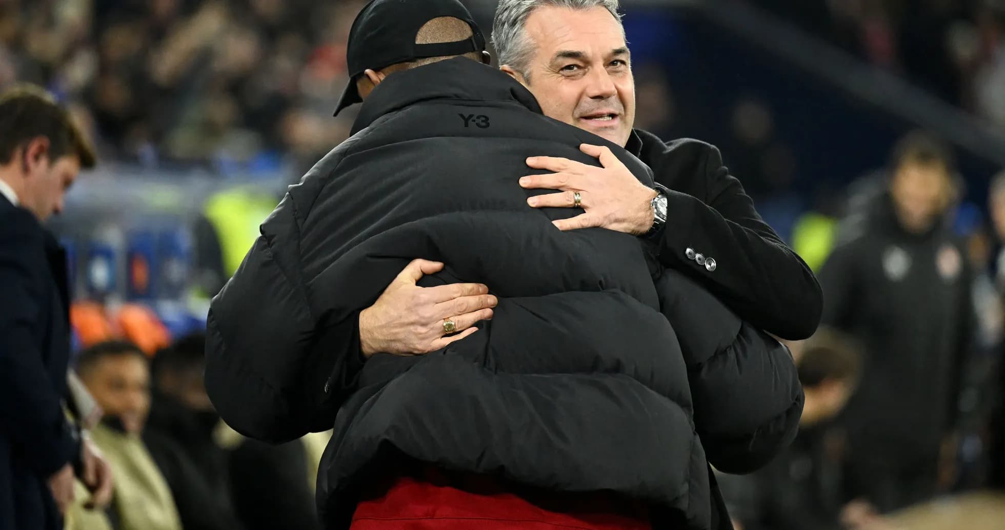 Two coaches embracing on the sideline