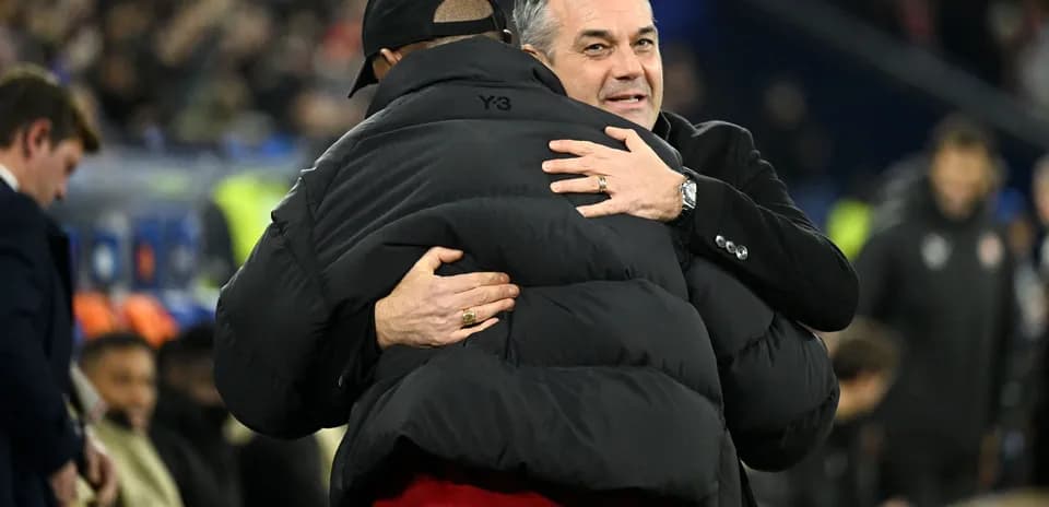 Two coaches embracing on the sideline