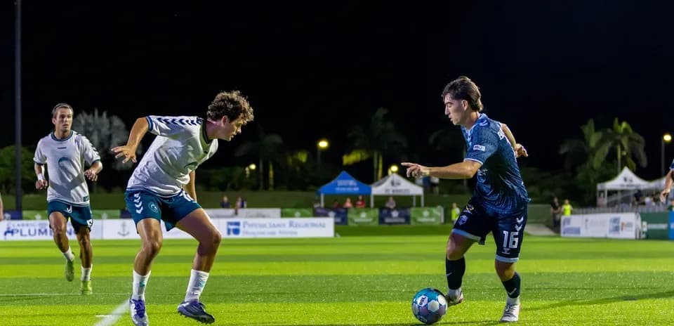 Two players competing for the ball in football match
