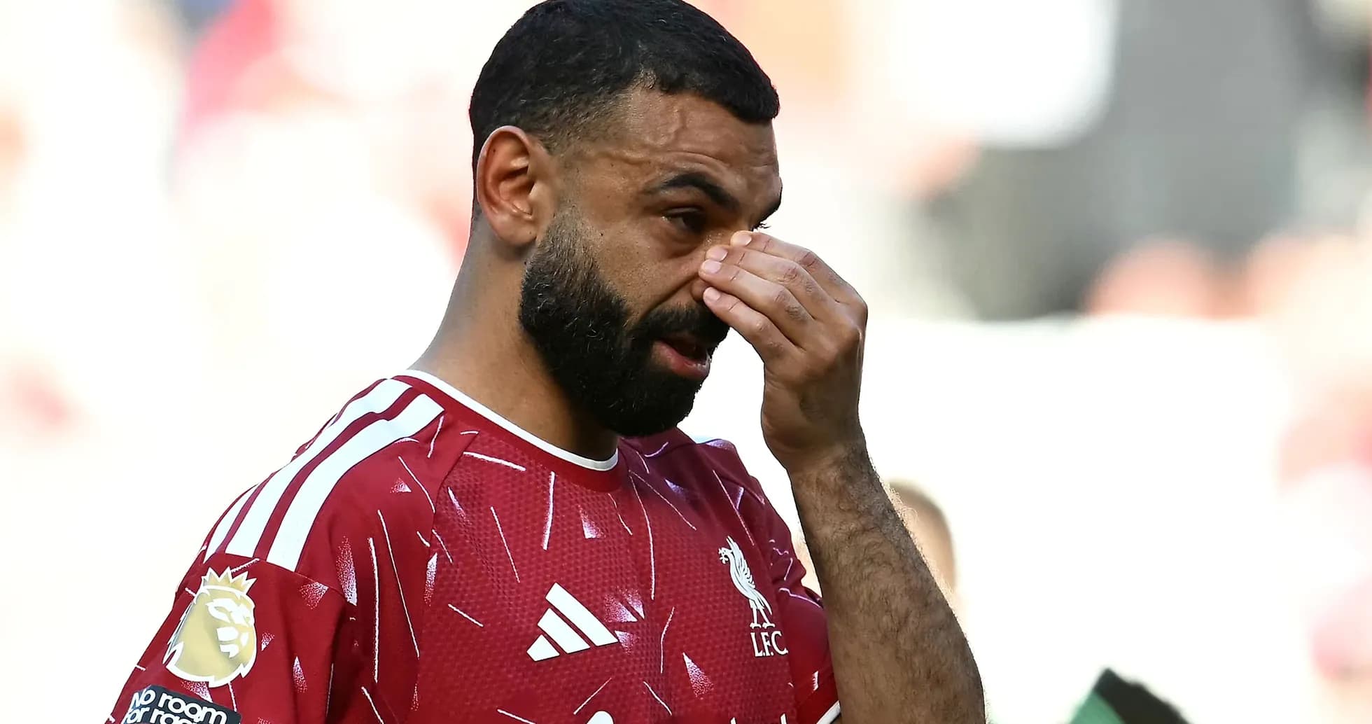 Player in Liverpool kit wiping his face