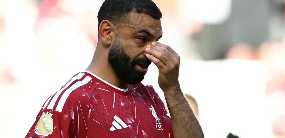 Player in Liverpool kit wiping his face