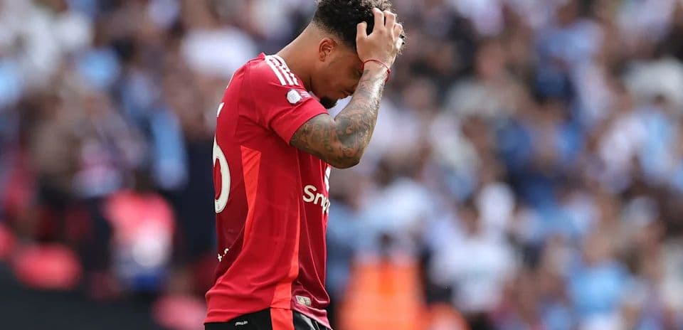 Player in red jersey holding head during match