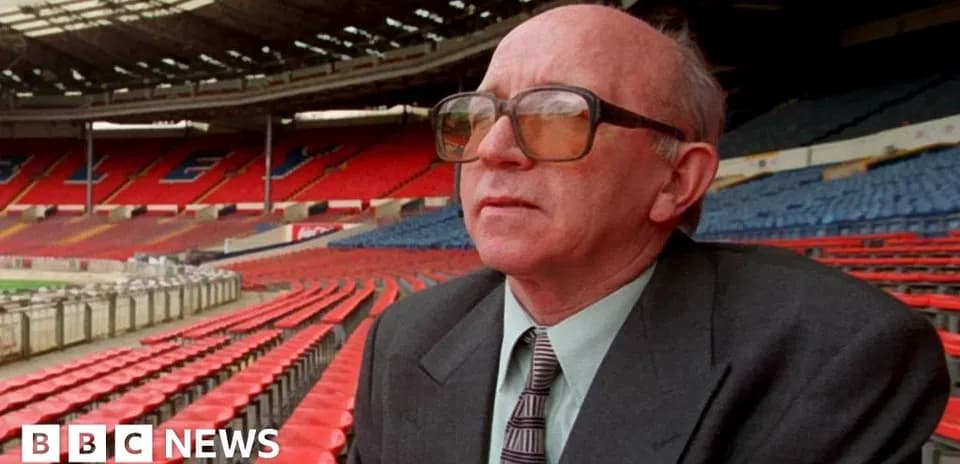 Man seated in empty stadium, looking ahead